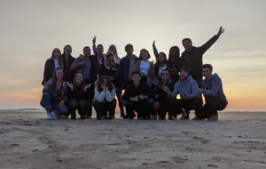Groupe de volontaires sur la plage, devant le coucher de soleil